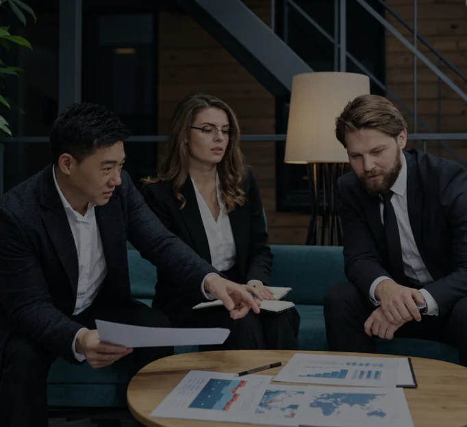 Three physicians reviewing case notes together at a meeting table.